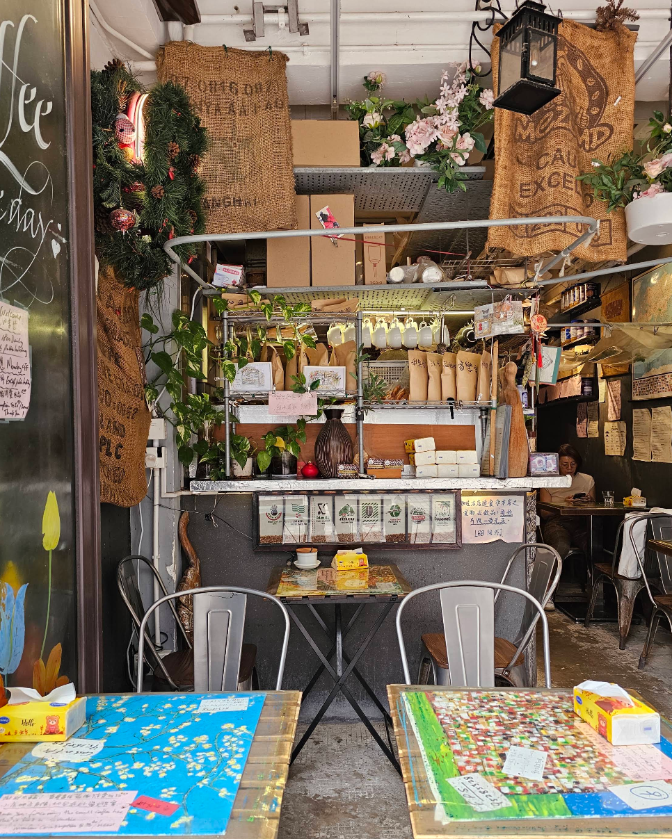 Inside Happiness Single Coffee: the counter with coffee bags, plants and hand-written notes